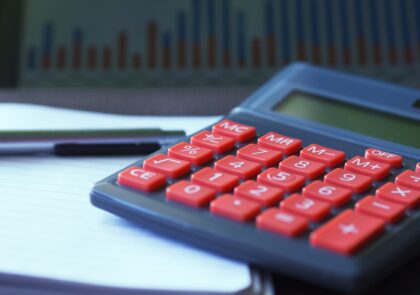 Kuvituskuva, jossa laskin, vihko ja taulukko