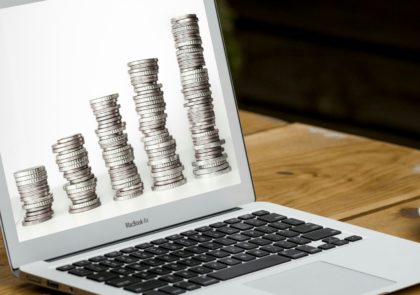 Kuvituskuva, jossa erimittaisia kolikkopinoja tietokoneen näytöllä