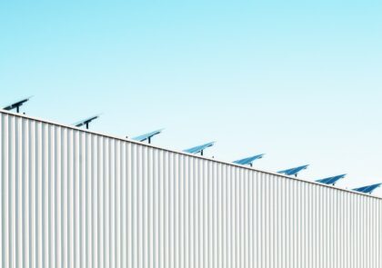 kuvituskuva, jossa aurinkopaneeleja rakennuksen katolla