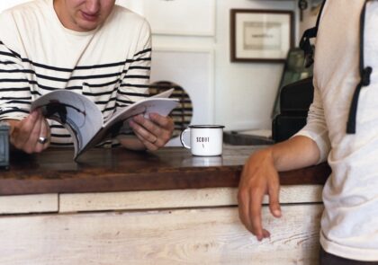 Kuvituskuva, jossa kaksi henkilöä keskustelee seisten pöydän ääressä