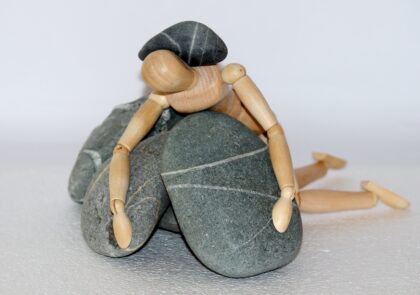 Kuvituskuva, jossa ihmistä esittävä lelu on jäänyt jumiin isojen kivien keskelle.