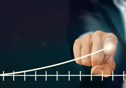 Kuvituskuva, jossa käden etusormi piirtää tilastokuvaajalla viivaa ylöspäin menestyksen merkiksi.en