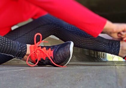 kuvituskuvassa nainen vetää lenkkikenkää jalkaansa