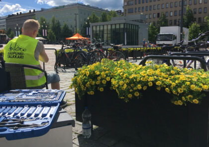 Worker of the guarded bicycle park sitting on a chair, ready to fix bicycles with a visible and open toolbox.