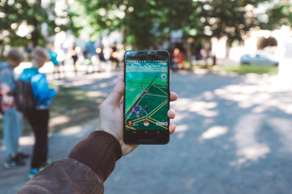 A player holding a smartphone and playing Pokémon Go.