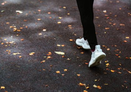 Kuvituskuvassa henkilö juoksee asflatilla, jolle pudonnut keltaisia lehtiä.