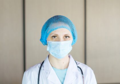 Lääkäri kasvomaskissa ja suojapäähineessä