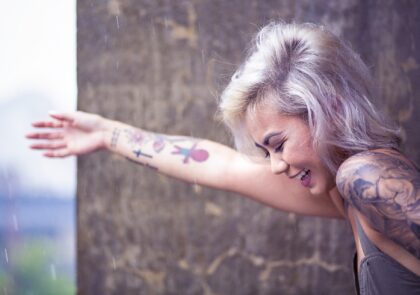 Kuvituskuvassa tyttö ojentaa oikeaa kättään, jossa näkyy useita tatuointeja.
