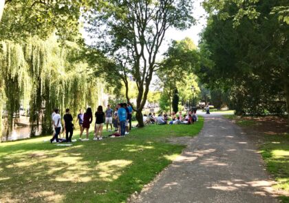 Opiskelijaryhmiä kesäisessä puistossa.