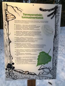 Image of an info board outdoors with text and illustration of tree trunks.