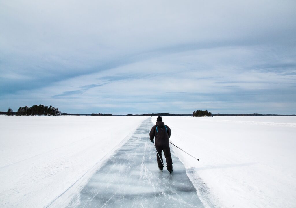 The illustration shows a skater on the ice of a lake.