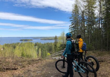 Kuvituskuvassa kaksi pyöräilijää ihailee maisemia Vääksyn Aurinkovuorella.