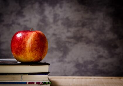 Kuvituskuva, jossa omena kirjapinon päällä