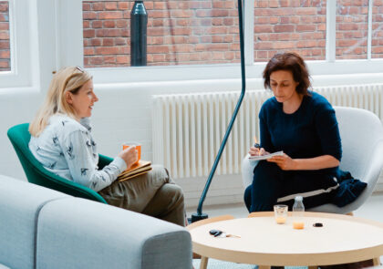 Kaksi henkilöä istuu nojatuoleissa avarassa toimistossa. Käynnissä on haastattelu.