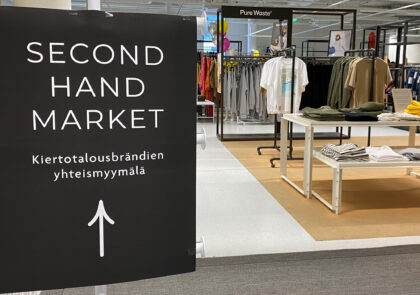 Kuvituskuvassa iso kyltti, jossa lukee Second hand market: Kiertotalousbrändien yhteismyymälä, ohjaa tasutalla näkyvään myymälään.