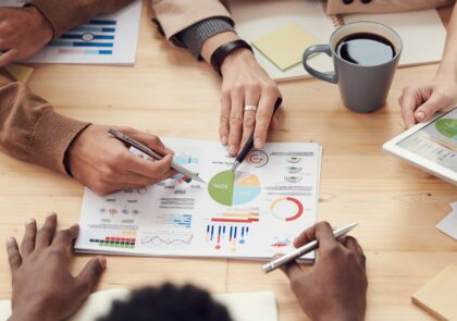 Ihmisiä yhdessä tutkimassa paperia jossa erilaisia kaavioita