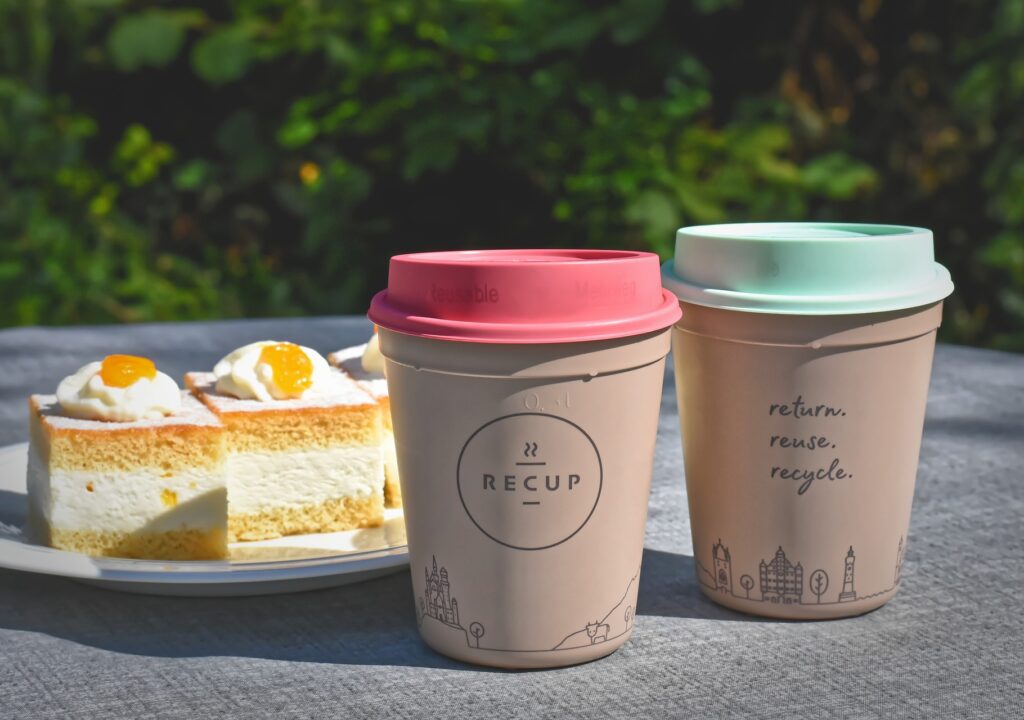 Reusable coffee cups next to cake