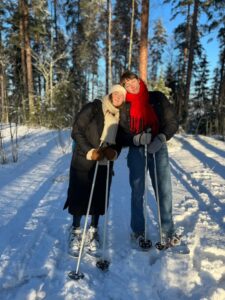 Two students have turned their faces to the sun in the snowy forest.