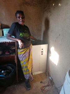 A woman showcasing her solar stove from her kitchen.