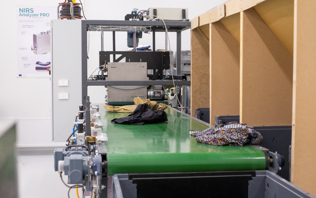 Tekstiililajittelulinjasto, jolla erilaisia tekstiilejä menossa materiaalinmukaisiin keräysastioihin.