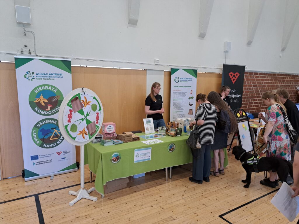 ASKI-hankkeen esittelypiste ja sen vieressä onnenpyörä sekä roll upit.