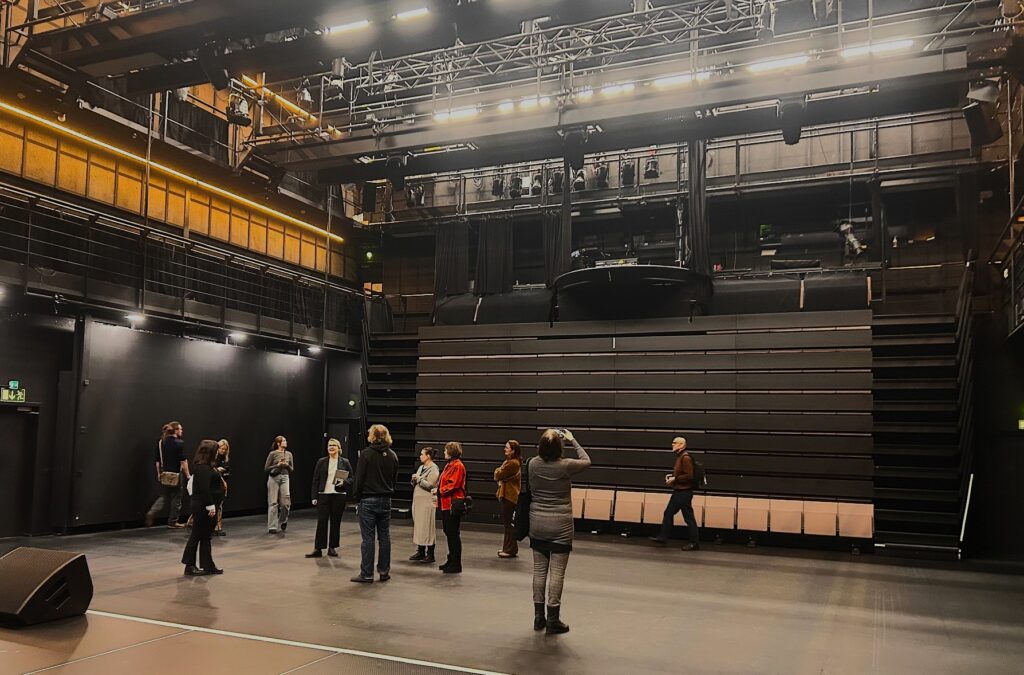 Joukko ihmisiä salissa.