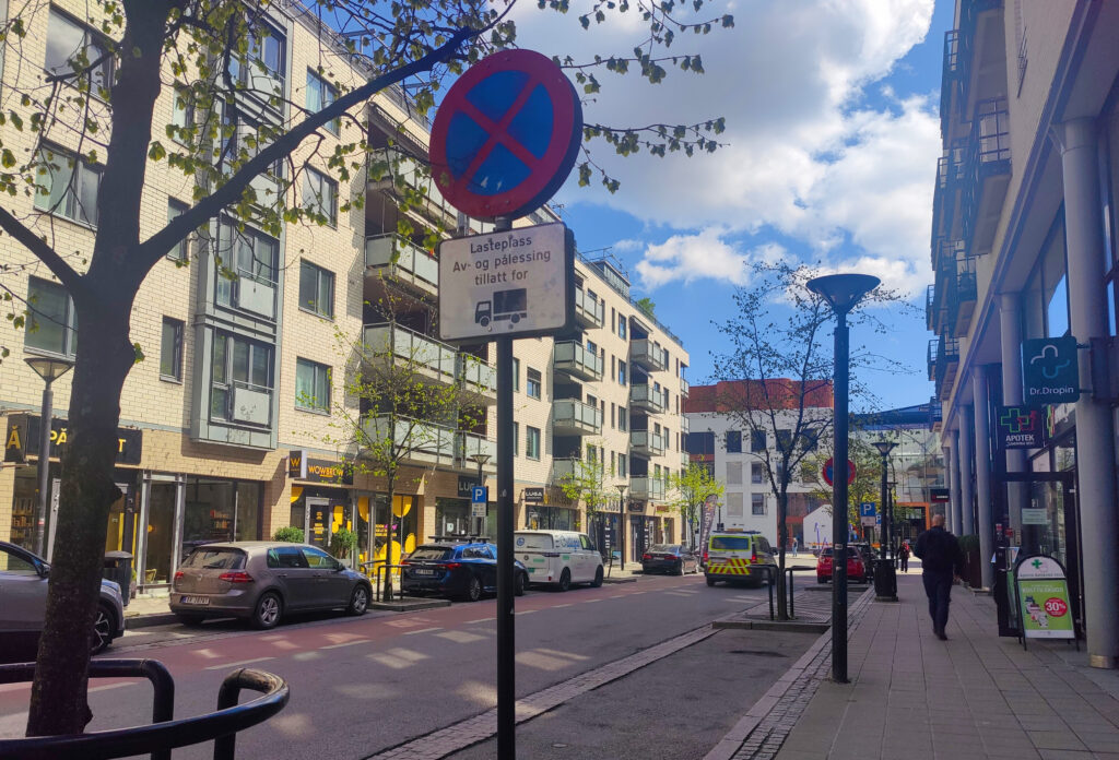 Pysäköintipaikka kadunvarrella ja kuormauspaikkaa osoittava pysäköintimerkki.